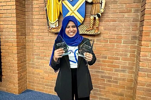 Photo of Raihaanah Ahmed with two awards