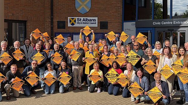 Group of Liberal Democrat Campaigners outside the Council offices holding yellow diamonds 